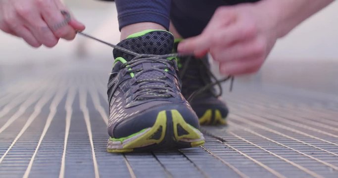 Woman tying her shoes before running.