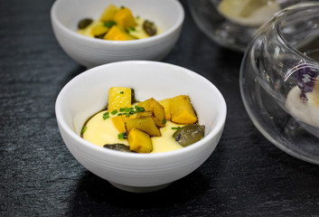 Bowls of vegetables and savoury mousse on a black slate in a restaurant