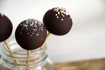 Three delicious chocolate cake pops in a jar.