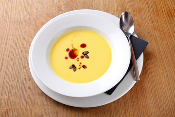 Bright yellow beautiful soup in a white plate