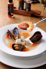 Healthy delicatessen seafood soup of white fish, shrimps and mussels