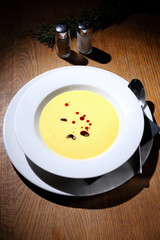 Bright yellow beautiful soup in a white plate