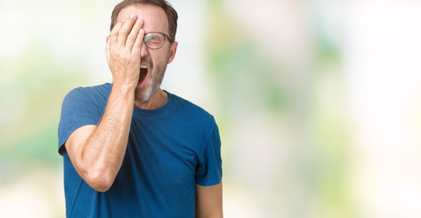 Handsome middle age hoary senior man wearin glasses over isolated background Yawning tired covering half face, eye and mouth with hand. Face hurts in pain.