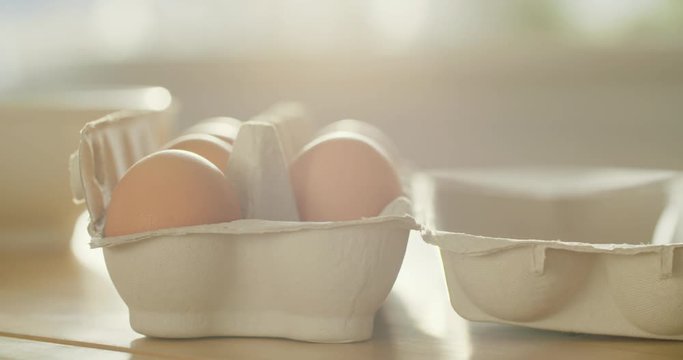 Slow motion shot of a female hand taking an egg out of a box.