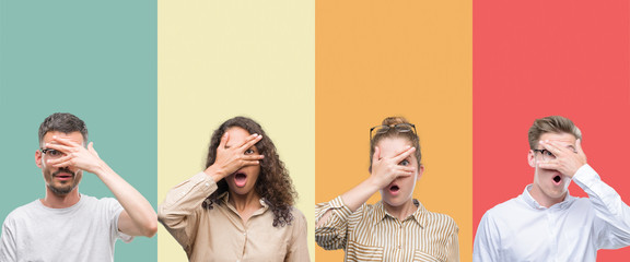 Collage of a group of people isolated over colorful background peeking in shock covering face and eyes with hand, looking through fingers with embarrassed expression.