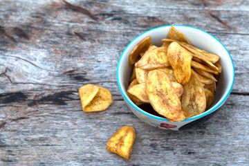 Homemade banana chips on wooden desk