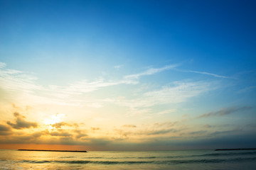 Beautiful early morning sunrise over the sea the horizon,blue sky background texture with white clouds sunset.