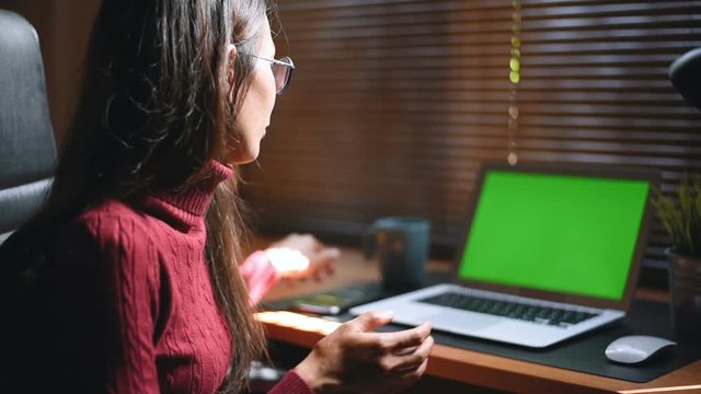 Woman working at home on with laptop green screen