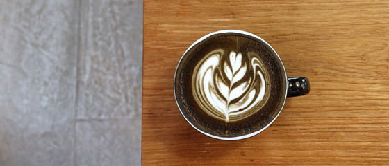 Fototapeta premium a cup of latte art coffee on wooden background