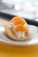 Orange topped on pancakes in coffee shop