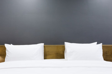 Close-up of white pillow on bed decoration in hotel bedroom interior.