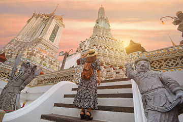 A woman tourist is traveling at Wat Arun in Bangkok, Thailand.