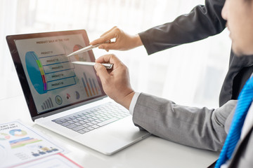 close up hand of marketing manager employee pointing at business document on laptop computer during discussion at meeting room  - Business concept