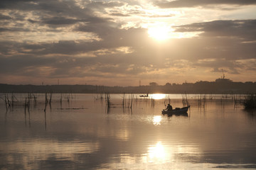 朝日の中釣りをする人