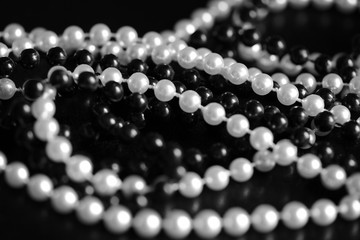 Necklace of black and white beads on a dark background close up. Black and white