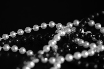 Necklace of black and white beads on a dark background close up. Black and white