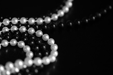 Necklace of black and white beads on a dark background close up. Black and white