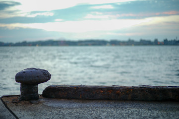 Selective focus of rusted steel post for seizing the ship at the pier