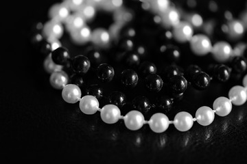 Necklace of black and white beads on a dark background close up. Black and white