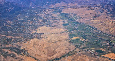 Aerial view of topographical Rocky Mountain landscapes on flight over Colorado and Utah during autumn. Grand sweeping views of rivers, mountain and landscape patterns. Top view, Rockies and Wasatch