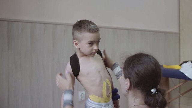 little caucasian during physiotherapy try to make basic movements