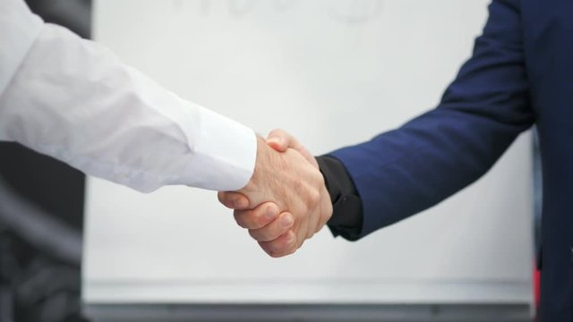 Close-up business handshake two male businesspeople shaking hands