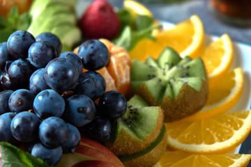 Naklejka na ściany i meble fruit plate. Glass bank of lemonade with sliced citrus fruits on a buffet table