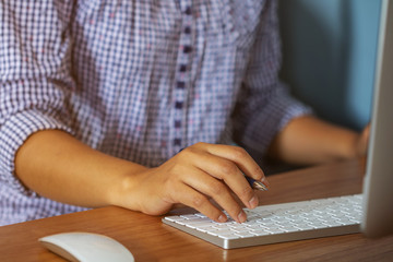 Lady working at home with computer,Her hand holding pen writing a blog and Creative idea of work 2019 goals, writing, drawing, making notes in document Business,investment,concept,Soft focus.