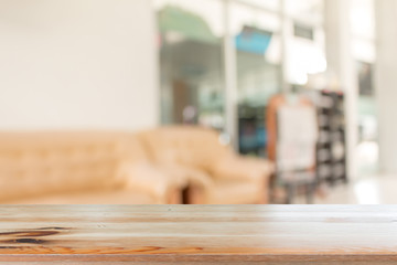 Wooden desk with Abstract blurred livingroom decoration interior for background