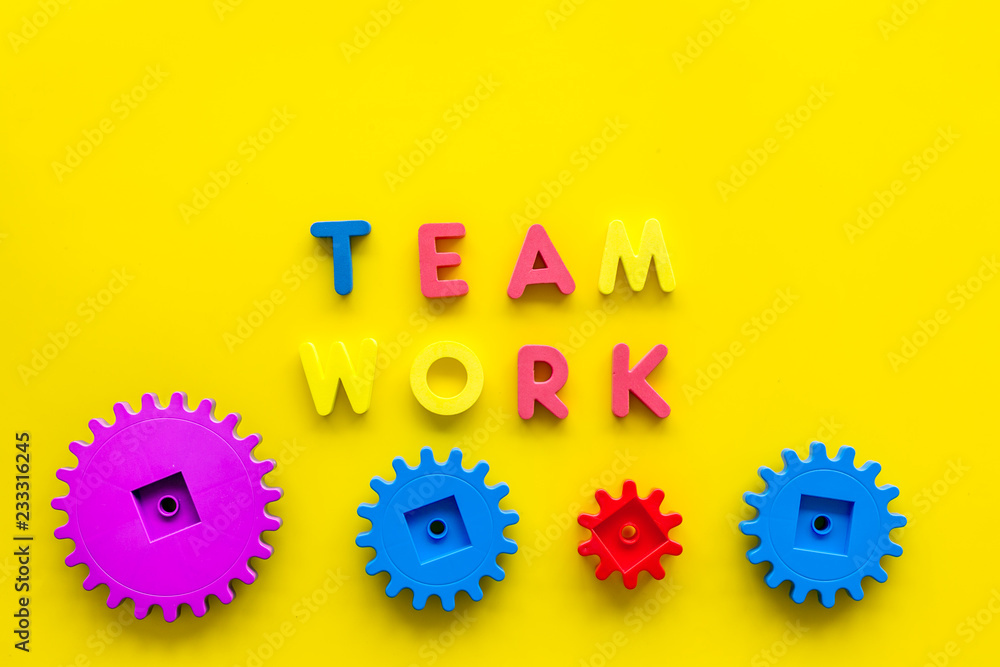 Aufkleber teamwork concept. text teamwork lined with colored letters near toy gears on yellow background top v