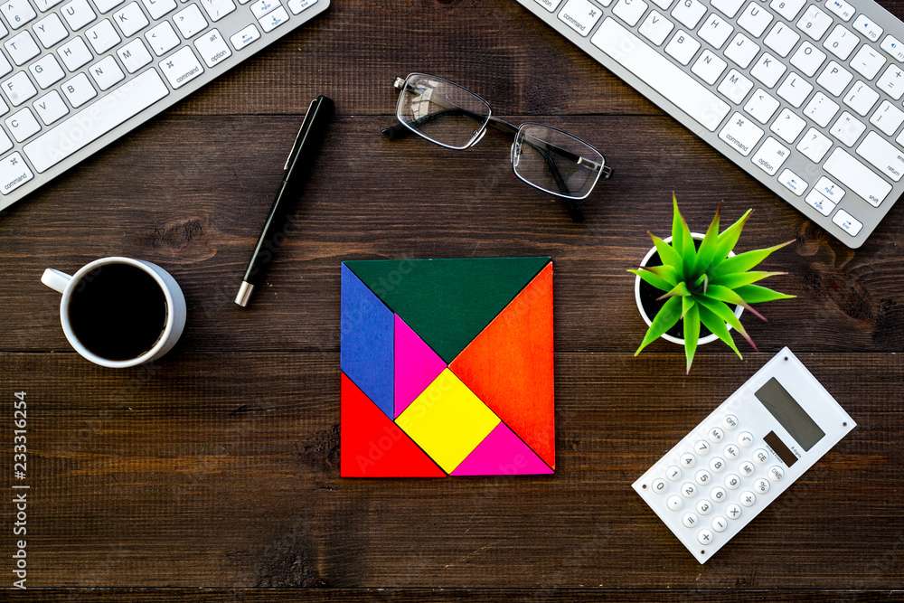 Poster teamwork in business concept. assembled puzzle on dark wooden office desk with computer keyboard top