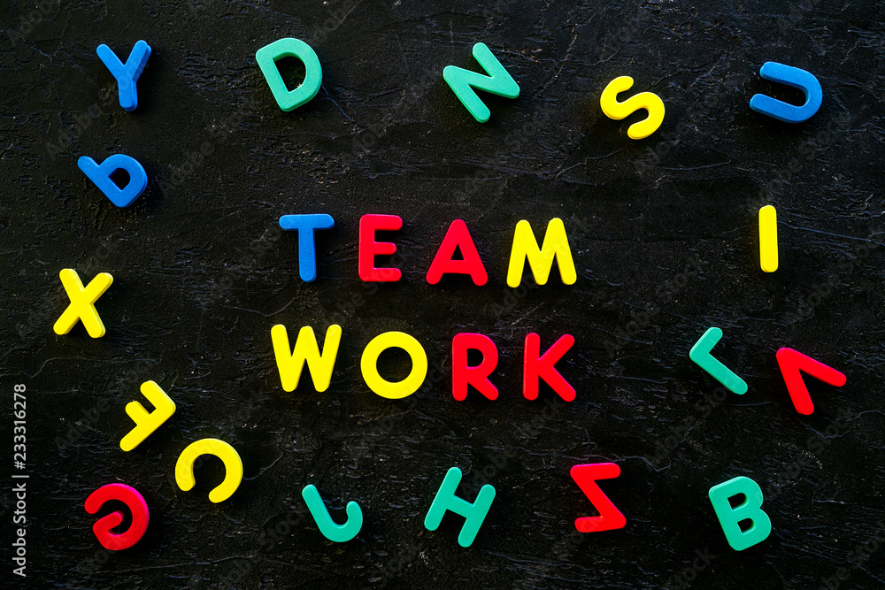 Aufkleber teamwork training concept. text teamwork lined with colored letters in frame of toy letters on black