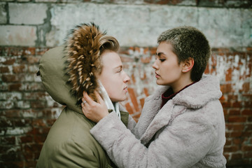 a girl holds a guy in the hood