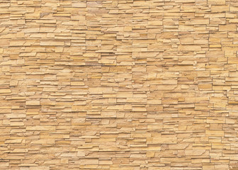 Rock stone brick tile wall aged texture detailed pattern background in light yellow cream  brown color