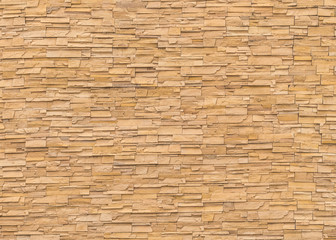 Rock stone brick tile wall aged texture detailed pattern background in dark cream beige brown color