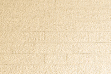 Limestone rock slab tile wall texture patterned background in light pastel cream yellow beige color