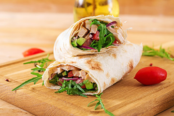 Tortillas wraps with chicken and vegetables on  wooden background. Chicken burrito. Healthy food.
