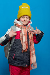 School girl with backpac in warm winter clothes.