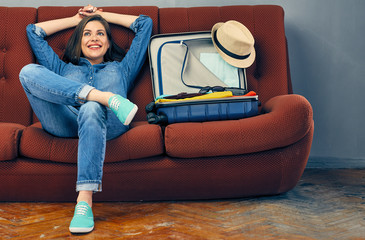 Happy smiling woman preparing suitcase for vacation travel.