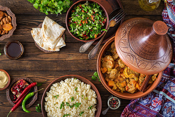 Traditional tajine dishes, couscous  and fresh salad  on rustic wooden table. Tagine lamb meat and pumpkin. Top view. Flat lay - obrazy, fototapety, plakaty