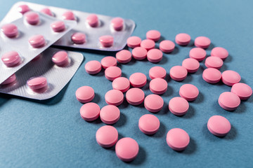 pink pills in a blister on a blue background