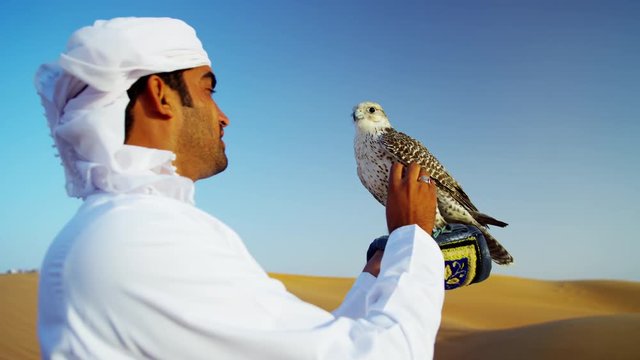 Middle Eastern Falconer In Desert With His Bird Of Prey