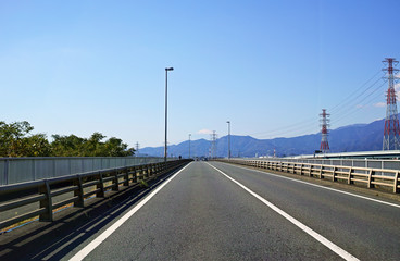 Fototapeta premium 遠くに丹沢山地と富士山が見える直線道路