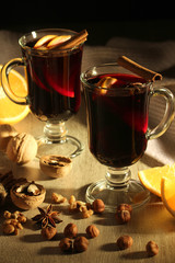Two cups with ready mulled wine with anise, cinnamon and nuts around