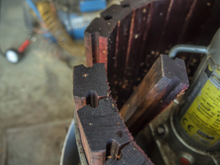Broken wooden board at side wall of wine press closeup.
