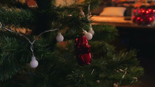 Little girl decorating christmas tree with color lights and shiny bulbs. Family time filmed in slow motion hd.