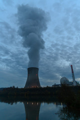 looking over a river at an atomic reactor cooling tower