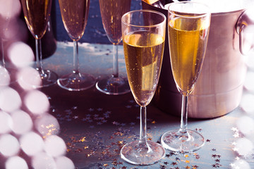 Champagne bottle in bucket with ice and glasses of champagne