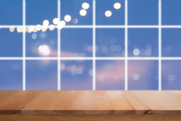 Wooden desk with Blurred light on road in city with bokeh abstract background