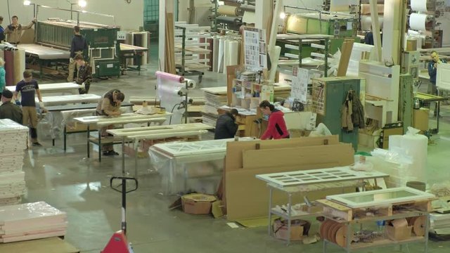 men and women, workers discuss the process of working in a large workshop. the process of making wooden doors
